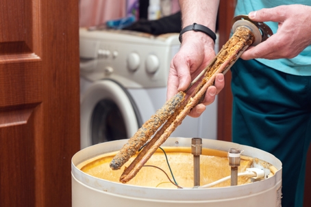 Man holding corroded heating element